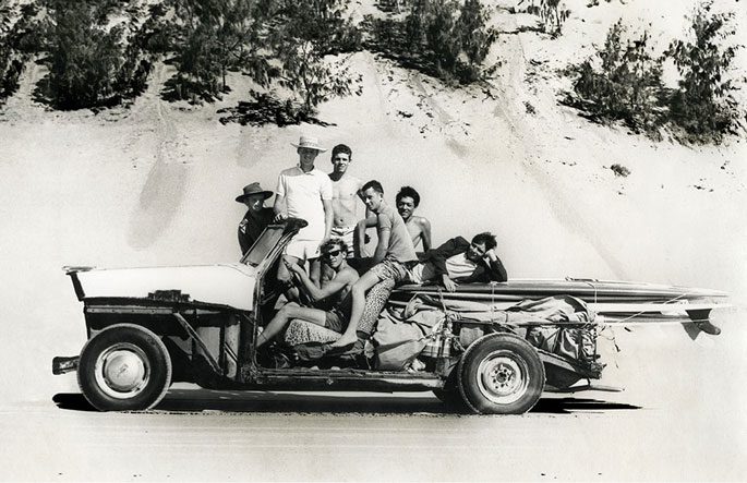 High school buddies and beach buggy on Rainbow Beach, Queensland (left to right): Kevin Lind, Graham Willett, Peter Sheppard (seated), Dave Clarke, Bruce Cowper, Norm Tong and Les Nixon. Photographer: Ron Lockens - keen surfer and recognised AFL photographer.
